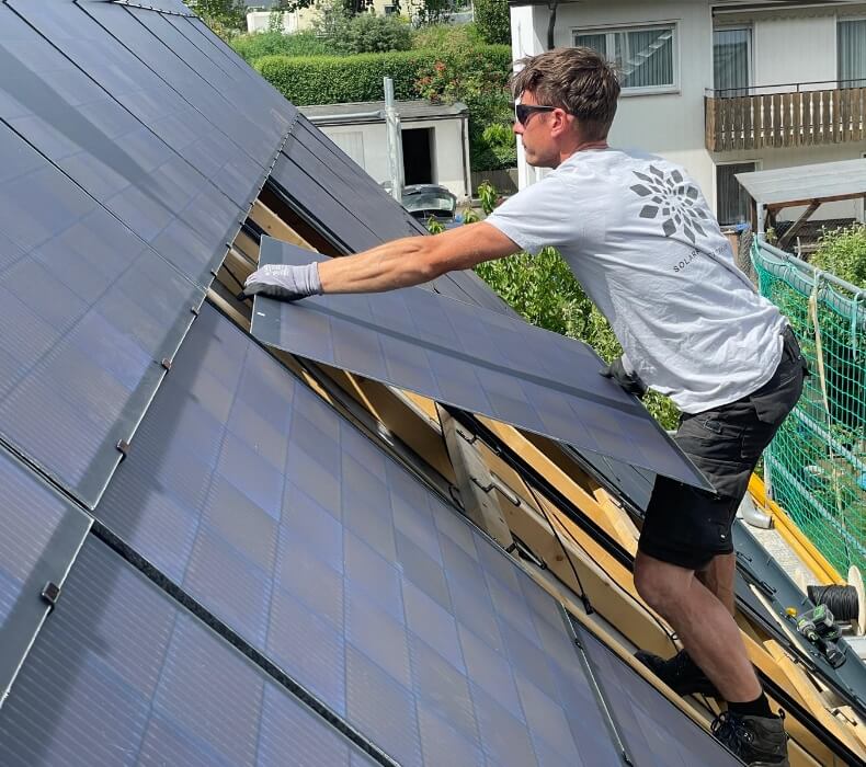 Mitarbeiter von Kaai Service montiert In-Dach Photovoltaik-Module auf einem Dach eines Einfamilienhauses
