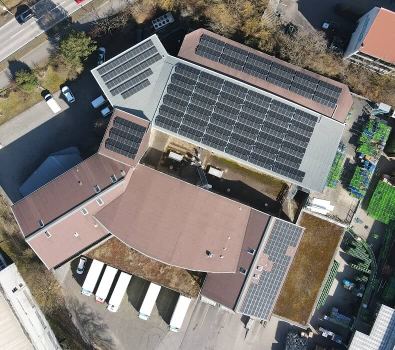 Drohnenaufnahme einer großen Photovoltaik-Anlage auf einem Industriegebäude
