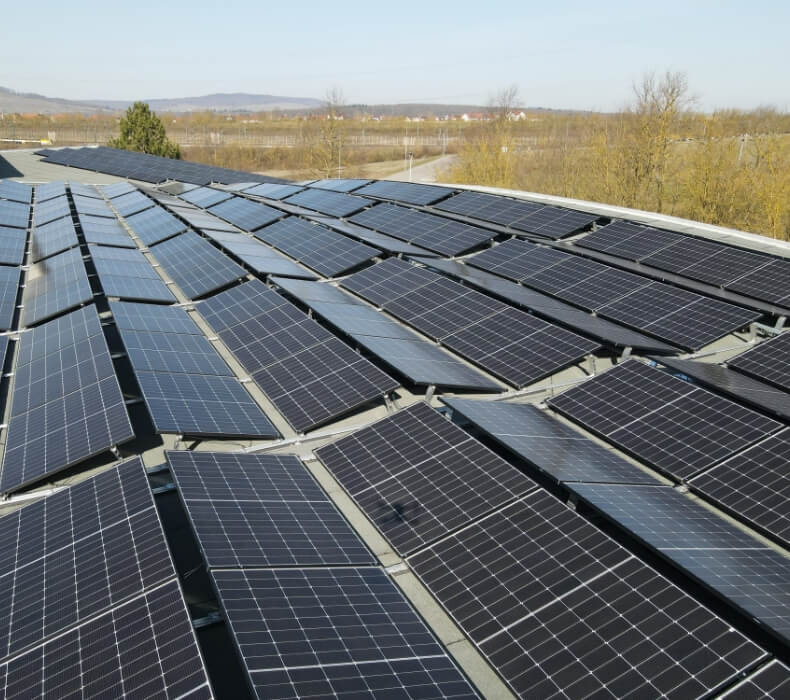 Drohnenaufnahme einer großen Photovoltaik-Anlage auf einem Industriegebäude - Flachdach mit Back-to-Back Aufständerung
